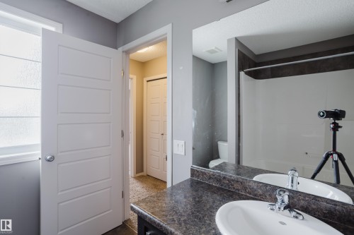 Bathroom featuring a vanity with a dark countertop, white sink, and a chrome faucet - 14009 164 Avenue, Edmonton, AB - Indoor Photo Showing Bathroom