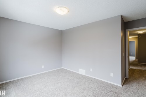 The room features light gray walls, a textured ceiling, and light-colored carpet flooring - 14009 164 Avenue, Edmonton, AB - Indoor Photo Showing Other Room