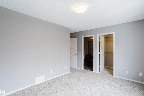 This property features light gray walls and light gray carpet, creating a bright and neutral aesthetic - 14009 164 Avenue, Edmonton, AB - Indoor Photo Showing Other Room