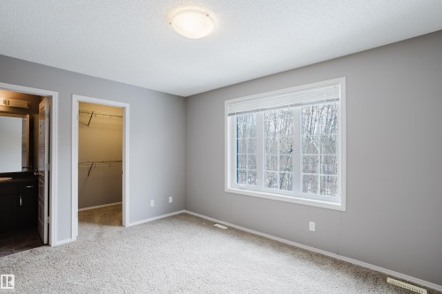 This room features soft gray wall paint, light-colored carpeting, and a large window with white blinds - 14009 164 Avenue, Edmonton, AB - Indoor Photo Showing Other Room