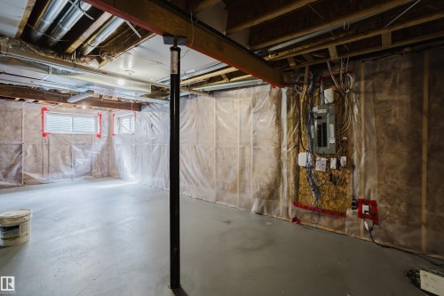 The property features an unfinished basement with exposed wooden beams, a support column, and an electrical panel - 14009 164 Avenue, Edmonton, AB - Indoor Photo Showing Basement
