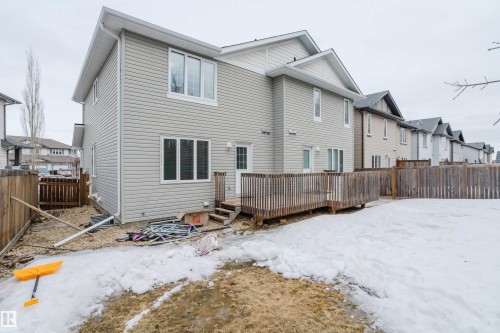 The property features an exterior with light-colored siding and a wooden deck - 14009 164 Avenue, Edmonton, AB - Outdoor With Exterior