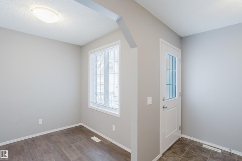 The property features a bright entrance area with a white paneled door with glass inserts, a window with blinds, and light-colored walls - 14009 164 Avenue, Edmonton, AB - Indoor Photo Showing Other Room