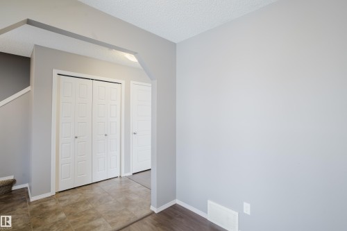 Entryway featuring light gray walls, white bifold doors, and tile flooring - 14009 164 Avenue, Edmonton, AB - Indoor Photo Showing Other Room