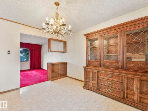 This space features a decorative chandelier, tile flooring, and a broad archway opening to an additional room - 5904 84 Avenue, Edmonton, AB - Indoor Photo Showing Other Room