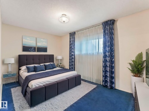 This room features blue carpeting, white walls, and a window with sheer and patterned blue curtains - 5904 84 Avenue, Edmonton, AB - Indoor Photo Showing Bedroom