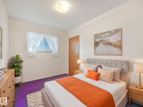 This room features a window with white sheer curtains, a light-colored wood dresser, and a ceiling light fixture - 5904 84 Avenue, Edmonton, AB - Indoor Photo Showing Bedroom