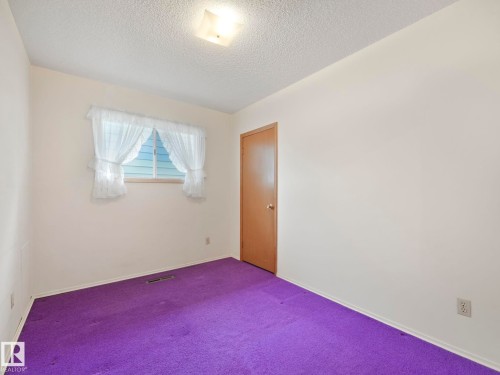 This room features a window with white curtains, a ceiling light fixture, and a door with a round knob - 5904 84 Avenue, Edmonton, AB - Indoor Photo Showing Other Room