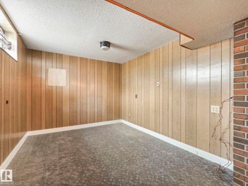 This room features wood paneling, a textured ceiling, and carpeted flooring - 5904 84 Avenue, Edmonton, AB - Indoor Photo Showing Other Room