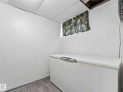 Utility area featuring white walls, a drop ceiling, and wood-look flooring - 5904 84 Avenue, Edmonton, AB - Indoor