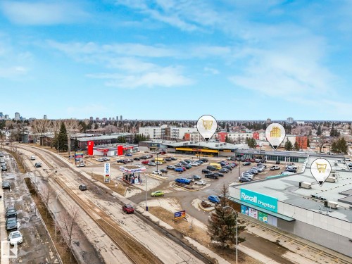 An aerial view of the property's surrounding community, featuring a retail plaza with a Rexall Drugstore, a gas station, and a parking lot - 5904 84 Avenue, Edmonton, AB - Outdoor With View