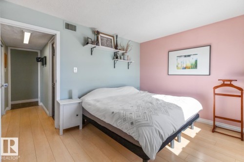 Bedroom with light wood-style floors and a textured ceiling - 1207 12303 Jasper Avenue, Edmonton, AB - Indoor Photo Showing Bedroom