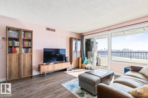 Living room with a textured ceiling and dark wood finished floors - 1207 12303 Jasper Avenue, Edmonton, AB - Indoor Photo Showing Living Room