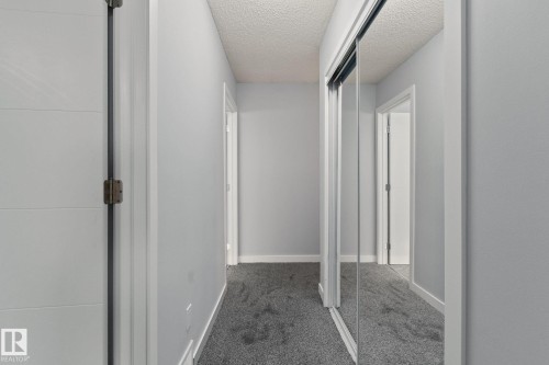 Hallway featuring plush grey carpet, neutral wall paint, and mirrored closet doors - 8620 38A Avenue, Edmonton, AB - Indoor Photo Showing Other Room