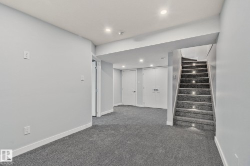 This spacious area features light gray walls, plush gray carpet, and recessed lighting - 8620 38A Avenue, Edmonton, AB - Indoor Photo Showing Other Room