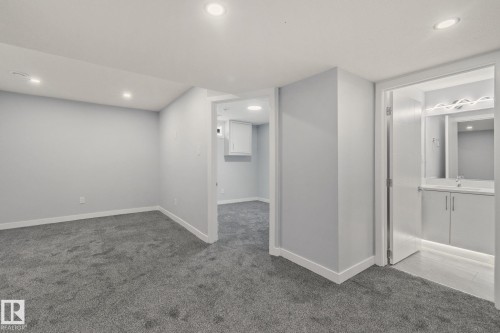 Spacious room with grey carpeted flooring and recessed lighting - 8620 38A Avenue, Edmonton, AB - Indoor