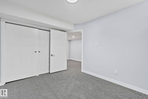 Bedroom with light grey carpet flooring, light grey walls, and a white ceiling - 8620 38A Avenue, Edmonton, AB - Indoor Photo Showing Other Room