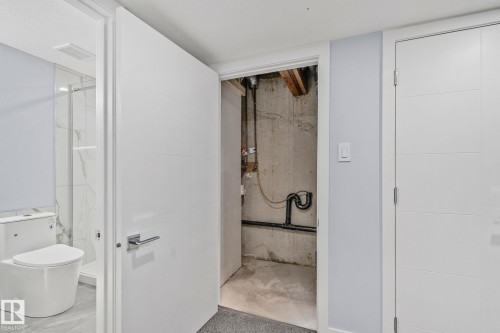 This property features a bathroom with a white toilet and a shower with glass enclosure, visible through an open door - 8620 38A Avenue, Edmonton, AB - Indoor