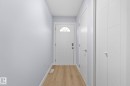 The property features light wood flooring, a white entry door with an arched window, and smooth light-colored walls - 8620 38A Avenue, Edmonton, AB  - Indoor Photo Showing Other Room 