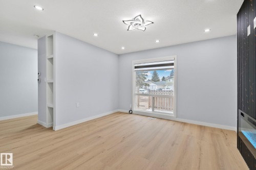 This bright living area features light-toned flooring, recessed lighting, and a modern ceiling fixture - 8620 38A Avenue, Edmonton, AB - Indoor Photo Showing Other Room