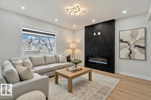 The living area features light-colored flooring, a decorative ceiling light fixture, and recessed lighting - 8620 38A Avenue, Edmonton, AB - Indoor Photo Showing Living Room