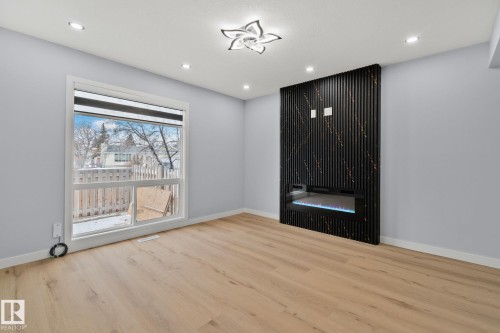 This space features light-toned flooring, recessed lighting, and a modern ceiling fixture - 8620 38A Avenue, Edmonton, AB - Indoor Photo Showing Other Room