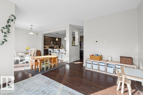 The property features dark hardwood flooring throughout this open concept living area - 1227 Secord Landing, Edmonton, AB - Indoor