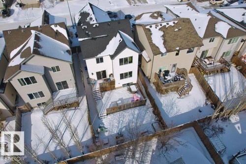 Aerial view of the property and its rear yard, featuring a wooden deck with steps and a fenced perimeter - 1227 Secord Landing, Edmonton, AB - Outdoor