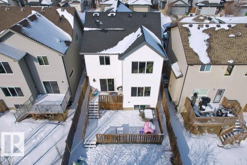 The property features a white exterior, a dark shingled roof, and a private fenced yard - 1227 Secord Landing, Edmonton, AB - Outdoor