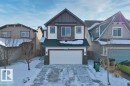 The property features a two-story exterior with a double garage, a paved driveway, and a front yard with trees - 1227 Secord Landing, Edmonton, AB  - Outdoor With Facade 