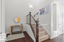 Inviting entryway featuring dark hardwood flooring, light grey walls, and a staircase with a dark wood banister and carpeted steps - 1227 Secord Landing, Edmonton, AB  - Indoor Photo Showing Other Room 