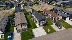 Residential street featuring multiple single-story homes, each with a front yard and concrete driveway - 