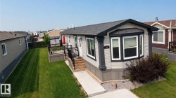 Siding exterior with a bay window, concrete walkway, and gravel landscaping - 
