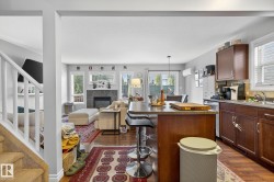 The property features an open living area with hardwood floors, a stone fireplace, and large windows - 
