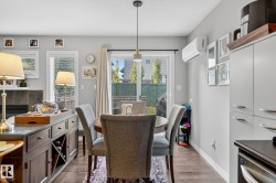 This dining area features hardwood flooring, a contemporary ceiling light fixture, and a sliding glass door providing access to the yard - 