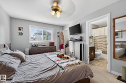 This bedroom features a ceiling fan, carpeted flooring, and a window with blinds - 