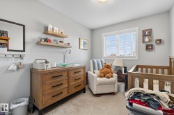 This room features light gray walls, a window with blinds, and light-colored carpeting - 