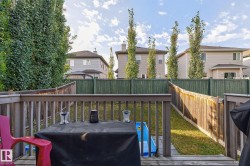The property features a wooden deck with a wooden railing overlooking a fenced yard - 