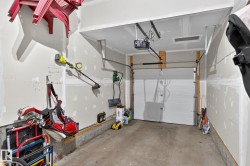 The property includes a garage featuring a white overhead door and an automatic opener - 