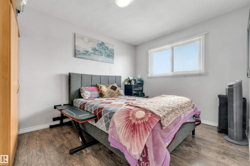 Bedroom featuring wood-style flooring, a window with blinds, and light-colored walls - 12908 126 Street, Edmonton, AB - Indoor Photo Showing Bedroom