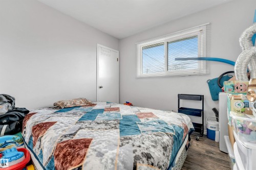 This room features light-colored walls and a window with horizontal blinds, providing natural light - 12908 126 Street, Edmonton, AB - Indoor Photo Showing Bedroom
