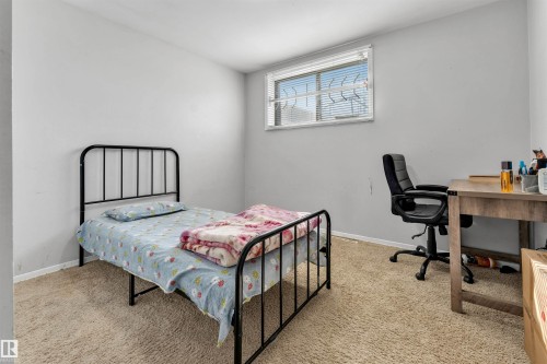This room features light-colored walls and carpeting, with a window providing natural light - 12908 126 Street, Edmonton, AB - Indoor Photo Showing Bedroom