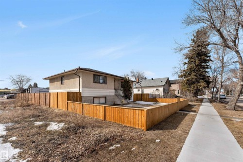 The property features a complete wooden fence enclosing a portion of the yard - 12908 126 Street, Edmonton, AB - Outdoor