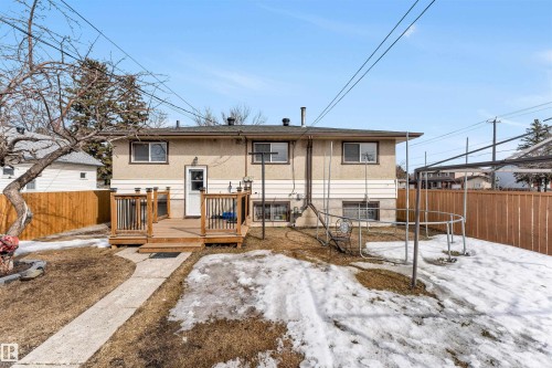 The property features a backyard with a wooden deck and a concrete pathway - 12908 126 Street, Edmonton, AB - Outdoor With Deck Patio Veranda