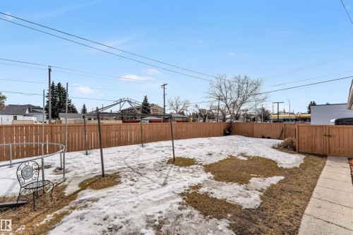 The property features a fenced yard with a clear pathway leading to a side gate - 12908 126 Street, Edmonton, AB - Outdoor