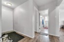 The property features wood-look flooring throughout the hallway, leading to a bathroom with a window and a toilet - 12908 126 Street, Edmonton, AB  - Indoor Photo Showing Other Room 