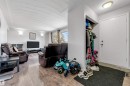 The property features a living area with wood-look flooring and sconce lighting - 12908 126 Street, Edmonton, AB  - Indoor 