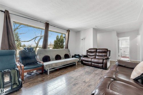 Spacious living area featuring large windows, wood-style flooring, and light-colored walls - 12908 126 Street, Edmonton, AB - Indoor Photo Showing Living Room
