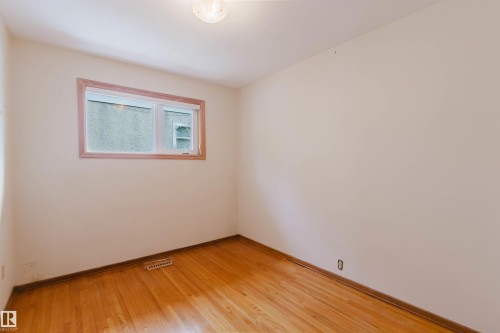 This room features hardwood floors and a window with wood trim - 11815 76 Avenue, Edmonton, AB - Indoor Photo Showing Other Room