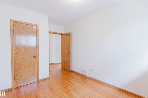 This interior features bright white walls and polished hardwood floors - 11815 76 Avenue, Edmonton, AB - Indoor Photo Showing Other Room